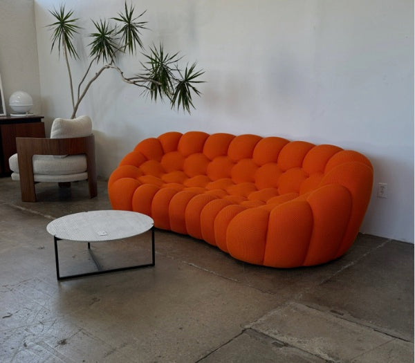 Canapé Rousseau orange dans un intérieur lumineux au sol béton — Orbe Paris