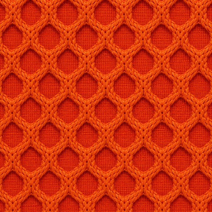 Gros plan du tissu technique Orbe Paris, teinte Orange vif — relief alvéolé visible.